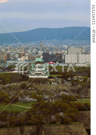 空から眺める大阪城鳥瞰図　桜の季節　生駒山系　春の青空に映える満開の桜 113457255