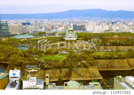 空から眺める大阪城鳥瞰図　桜の季節　生駒山系　春の青空に映える満開の桜 113457262