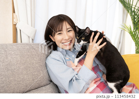 猫を抱いて微笑む女性 113458432