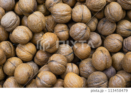 Walnuts with shells in the box in the grocery store Walnuts with shells in the box in the grocery store 113458479