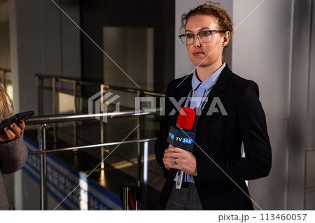 Female journalist watching a press conference Female journalist watching a press conference 113460057