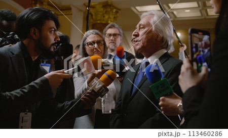 Senior diplomat surrounded by crowd of journalists 113460286