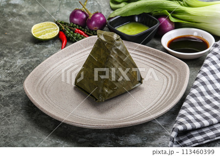 Asian cuisine - rice with filling in banana leaf Asian cuisine - rice with filling in banana leaf 113460399