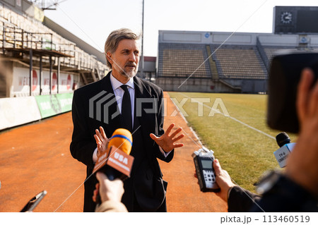 Interview of private investor for TV news in soccer stadium 113460519
