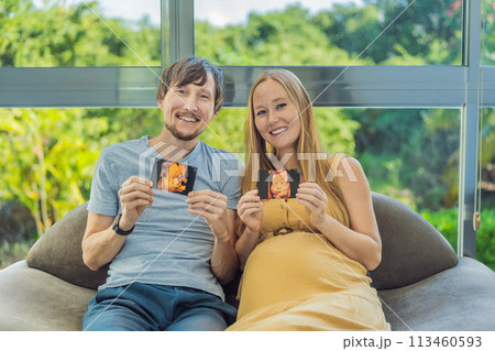 In a touching moment, the pregnant woman and father connect via video call, sharing the joy as they hold up an ultrasound photo, bridging the distance with the anticipation of their baby's arrival 113460593
