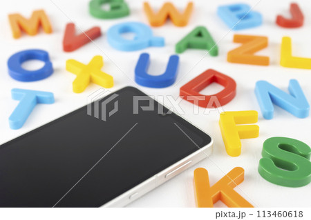 スマートフォンとアルファベット。英語の勉強アプリのイメージ スマートフォンとアルファベット。英語の勉強アプリのイメージ 113460618