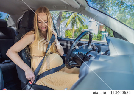 Pregnant woman driving with safety belt on in the car. Confident and capable, a pregnant woman takes the wheel, driving with care and determination as she navigates the journey of motherhood Pregnant woman driving with safety belt on in the car. Confident and capable, a pregnant woman takes the wheel, driving with care and determination as she navigates the journey of motherhood 113460680