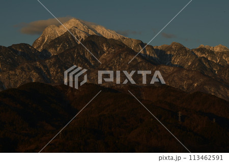 朝日を受けて白く輝く雲を乗せた南アルプス甲斐駒ケ岳 113462591