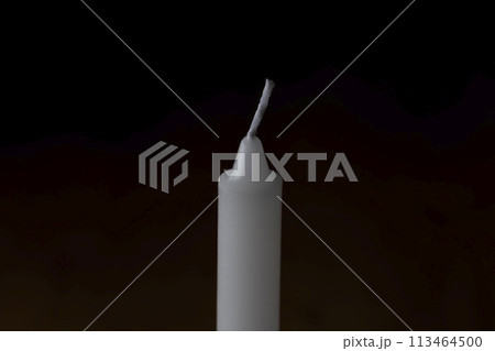 暗い背景に火のついていないロウソク 113464500