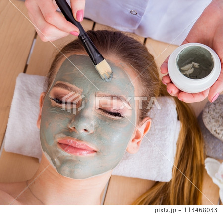 Young woman in spa health concept with face mask 113468033