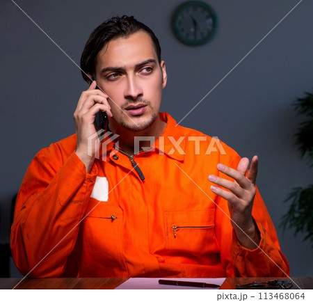 Young convict man sitting in dark room Young convict man sitting in dark room 113468064