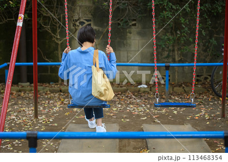 公園で時間つぶしをする女性　後ろ姿 113468354