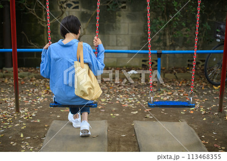 公園で時間つぶしをする女性　後ろ姿 113468355
