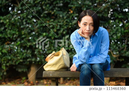 ベンチに座って悩む女性 113468360