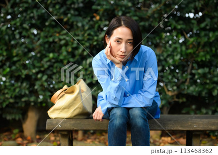 ベンチに座って悩む女性 ベンチに座って悩む女性 113468362