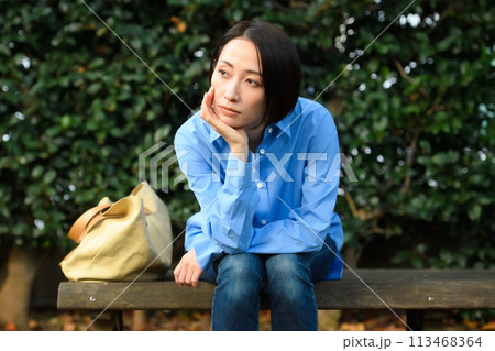 ベンチに座って悩む女性 ベンチに座って悩む女性 113468364