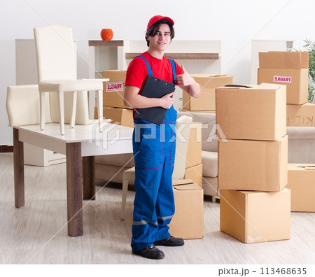 Young male contractor with boxes working indoors 113468635