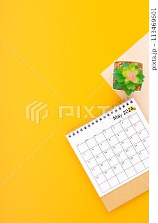Calendar page for May 2024 and houseplant on yellow background. 113469601