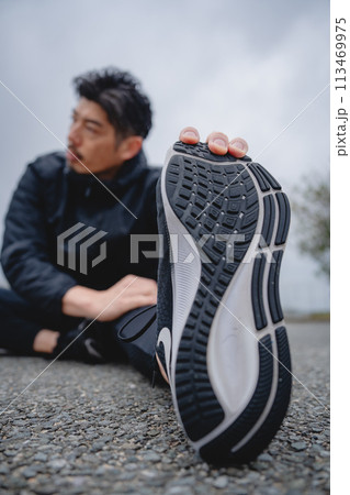 屋外で柔軟体操をする男性 113469975