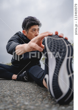 屋外で柔軟体操をする男性 113469979