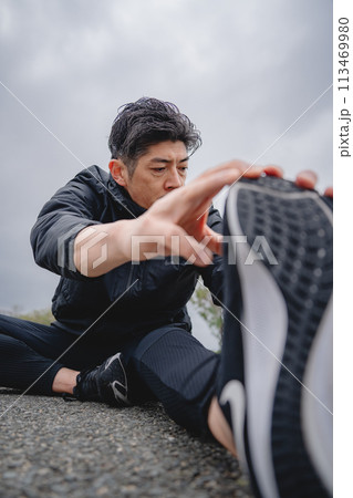 屋外で柔軟体操をする男性 113469980