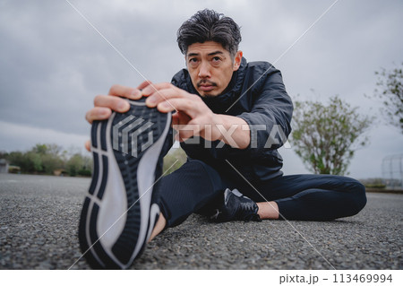 屋外で柔軟体操をする男性 113469994