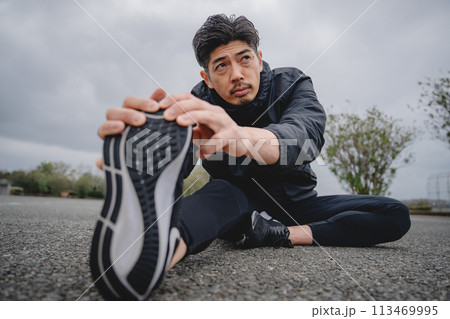 屋外で柔軟体操をする男性 113469995