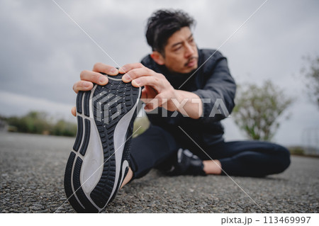 屋外で柔軟体操をする男性 113469997