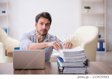 Young male employee and too much work in the office 113470563