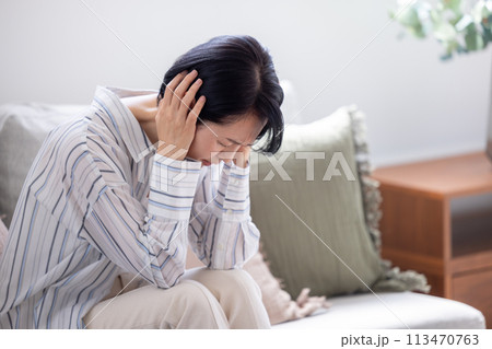 体調不良 頭痛 頭をおさえるミドル女性 体調不良 頭痛 頭をおさえるミドル女性 113470763