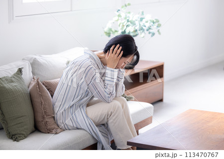 体調不良　頭痛　頭をおさえるミドル女性 113470767
