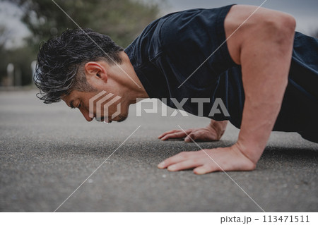 屋外で筋トレをする40代男性 113471511