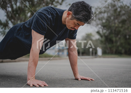 屋外で筋トレをする40代男性 113471516