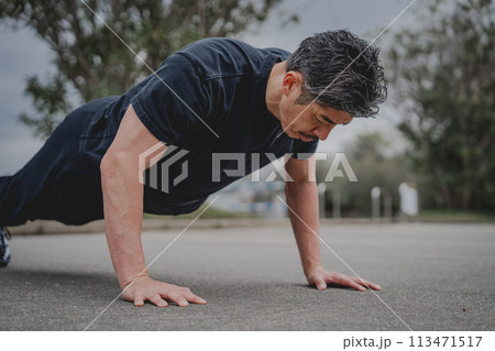 屋外で筋トレをする40代男性 113471517