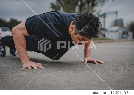 屋外で筋トレをする40代男性 113471525