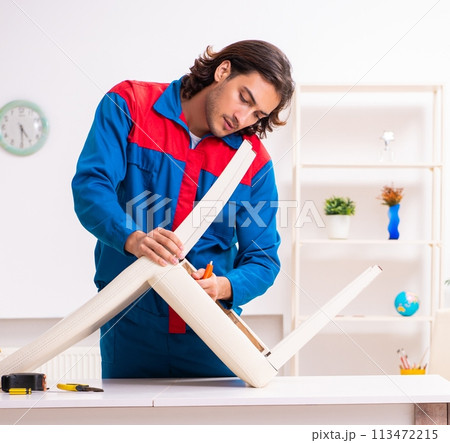 Young male carpenter working indoors 113472215