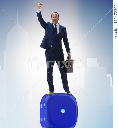 Businessman balancing on top of dice stack in uncertainty concep Businessman balancing on top of dice stack in uncertainty concep 113472305