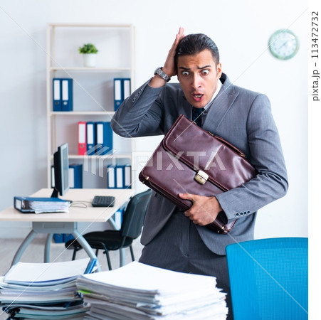 Businessman with heavy paperwork workload Businessman with heavy paperwork workload 113472732