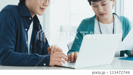 パソコンで仕事をする若い男女 113472749