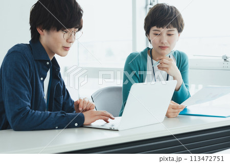 パソコンで仕事をする若い男女 113472751