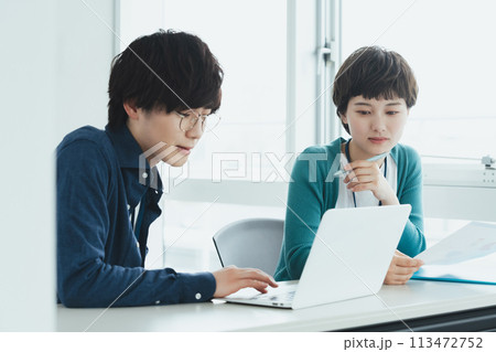 パソコンで仕事をする若い男女 113472752