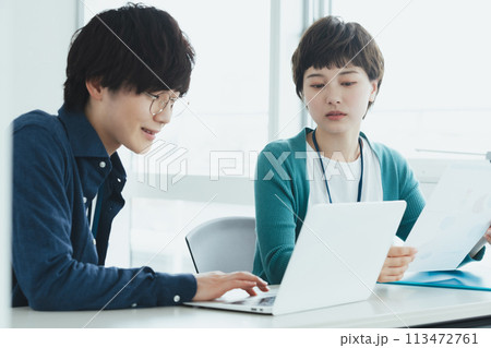 パソコンで仕事をする若い男女 113472761