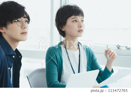 パソコンで仕事をする若い男女 113472765