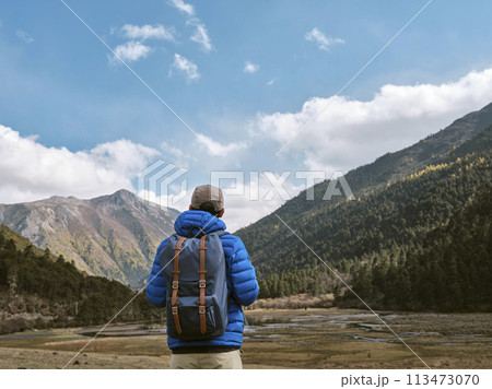 rear view of asian man looking at view while traveling rear view of asian man looking at view while traveling 113473070