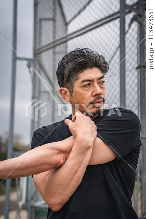 屋外で準備運動をする男性 113473651