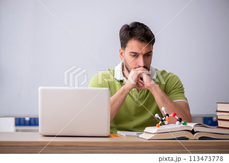 Young male student physicist sitting in the classroom 113473778