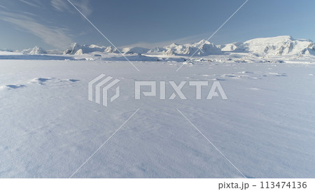 Infinitely, Infinitely polar snowy desert in Antarctica. South Pole frost surface. Scientific base. Snow covered mountains on horizon. Aerial view flight. Ice Landscape. Winter frozen ground drone fly Infinitely, Infinitely polar snowy desert in Antarctica. South Pole frost surface. Scientific base. Snow covered mountains on horizon. Aerial view flight. Ice Landscape. Winter frozen ground drone fly 113474136
