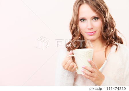 Autumn woman holds mug with coffee warm beverage Autumn woman holds mug with coffee warm beverage 113474230