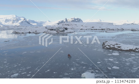 People in rubber inflatable motor boat sail in Antarctic ice to Akademik Vernadsky polar station. Tracking Aerial View. Expedition Transport Exploring Extreme Cold Water. Drone People in rubber inflatable motor boat sail in Antarctic ice to Akademik Vernadsky polar station. Tracking Aerial View. Expedition Transport Exploring Extreme Cold Water. Drone 113474289