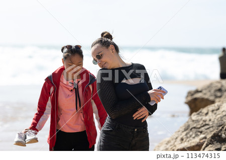 Woman and Young Girl Walking on the Beach 113474315